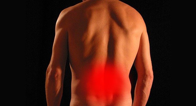 Picture of back of a naked man with red glow around the middle back to show where the pain is.