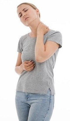 Woman clutching her neck indicating where her neck pain and shoulder pain may be radiating from.