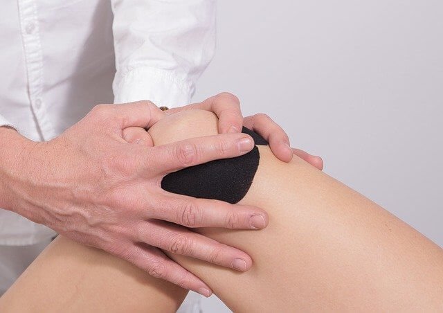Heallthcare practitioner holding the knee 